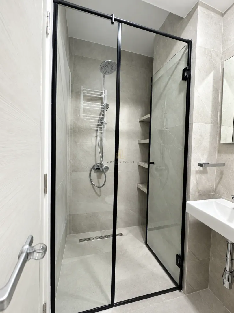 Modern bathroom with a walk-in shower and a washbasin.