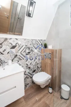 A modernly equipped bathroom with a washbasin, toilet, and shower cabin. - image 6
