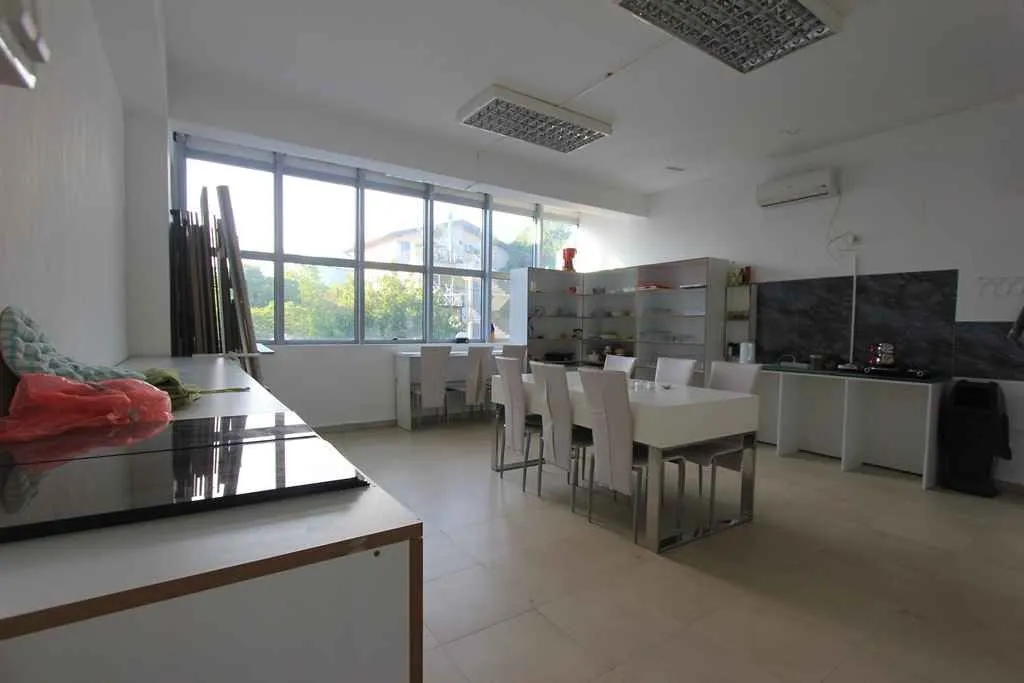 Large kitchen with a dining table and large windows.