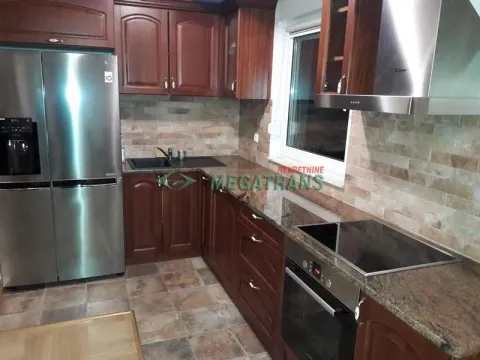Kitchen with dark wooden cabinetry, built-in appliances, and a large refrigerator. - image 13