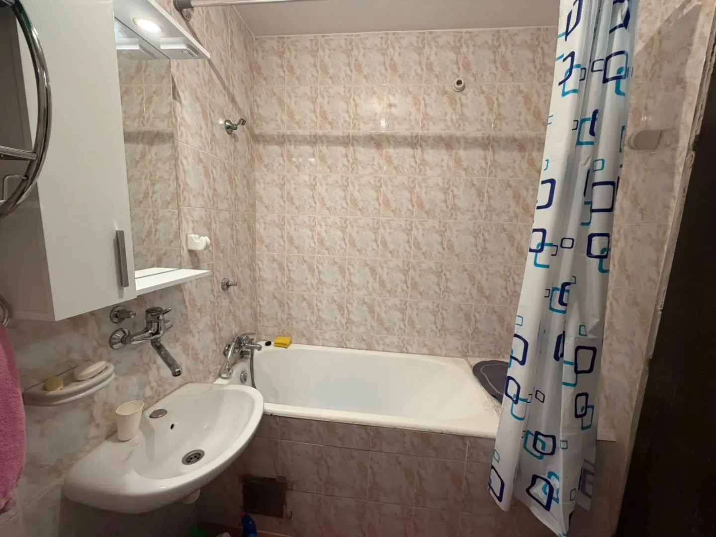 Small bathroom with a bathtub, sink, and mirror.