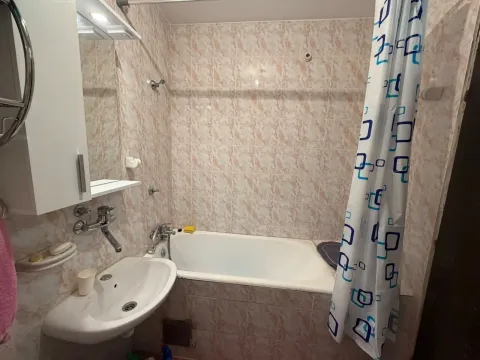 Small bathroom with a bathtub, sink, and mirror. - image 3