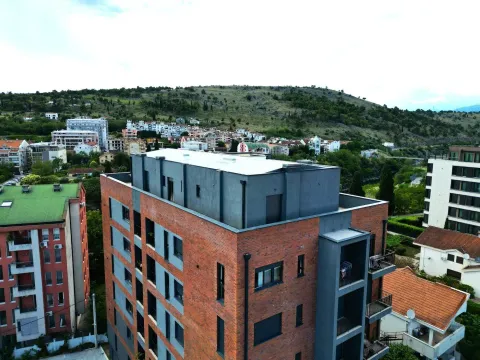 Aerial view of a modern apartment building with the surrounding neighborhood. - image 2