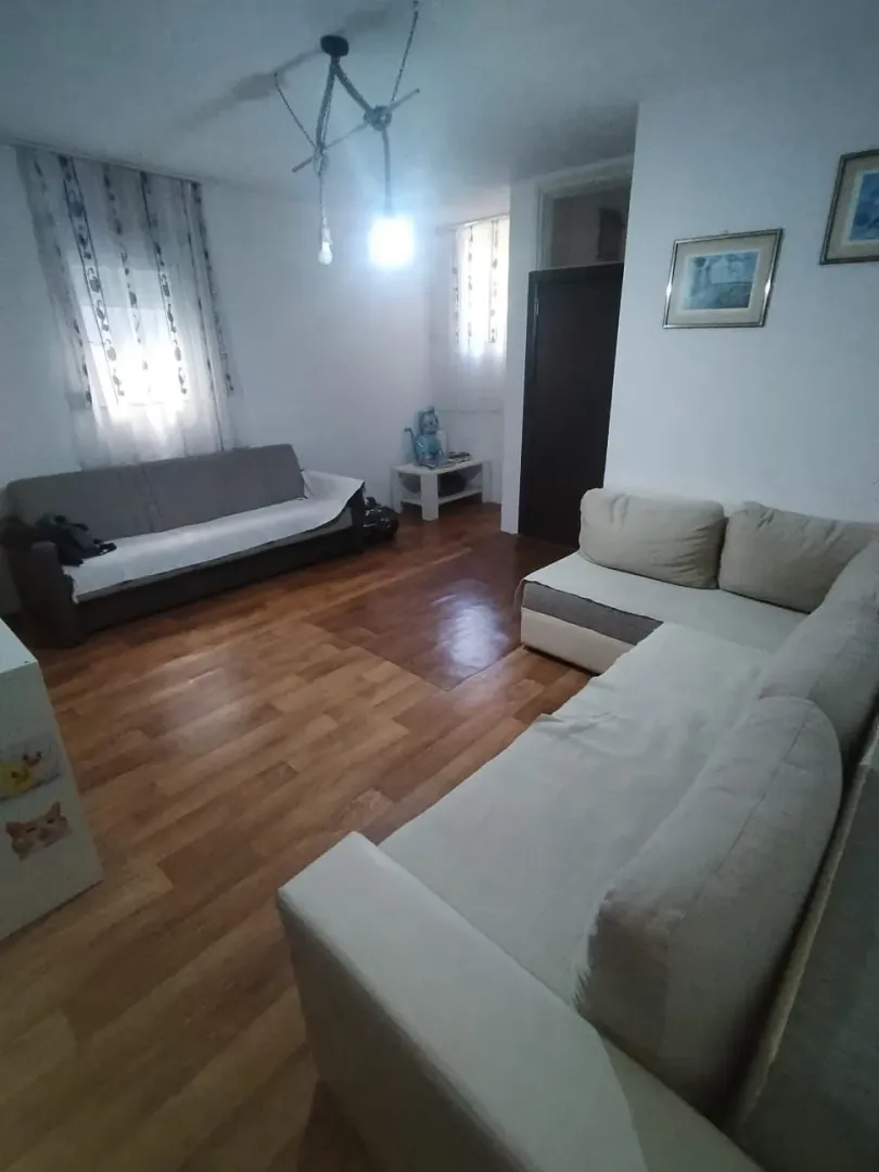 Spacious living room with a seating set and wooden flooring.