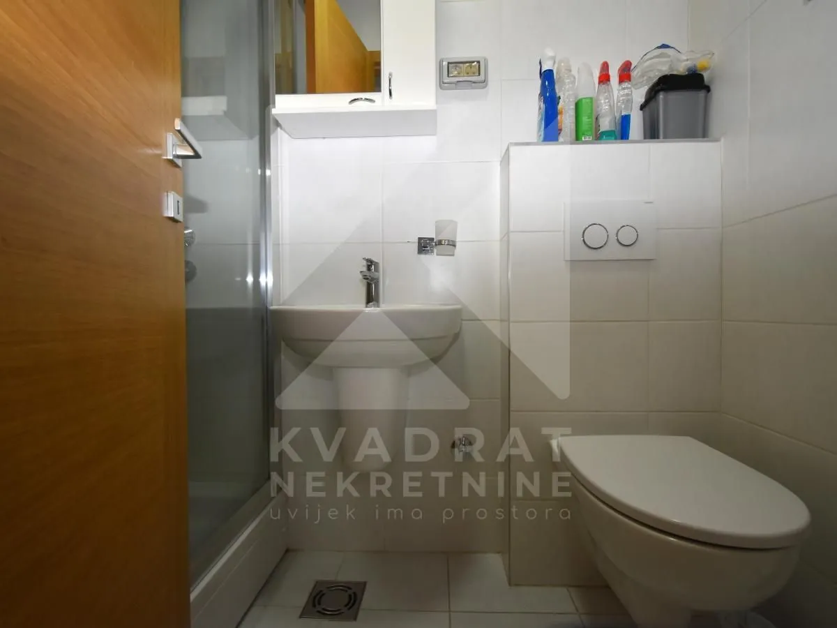 Manje kupatilo sa tuš kabinom, umivaonikom i wc šoljom.