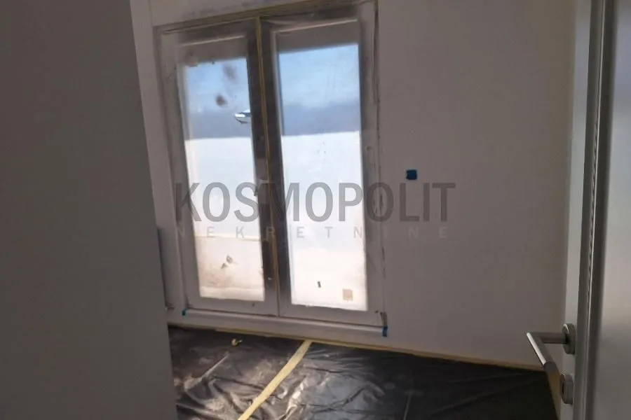 Prazna prostorija u toku renoviranja sa zaštitnom folijom na podu.