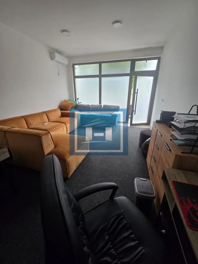 Living room with a sofa, desk, and access to the terrace.