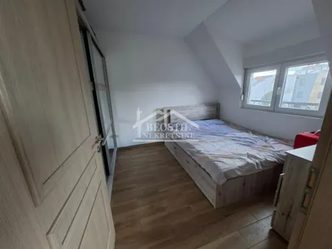 Manja spavaća soba sa bračnim krevetom, drvenim podom i prozorom pod kosinom. - image 8