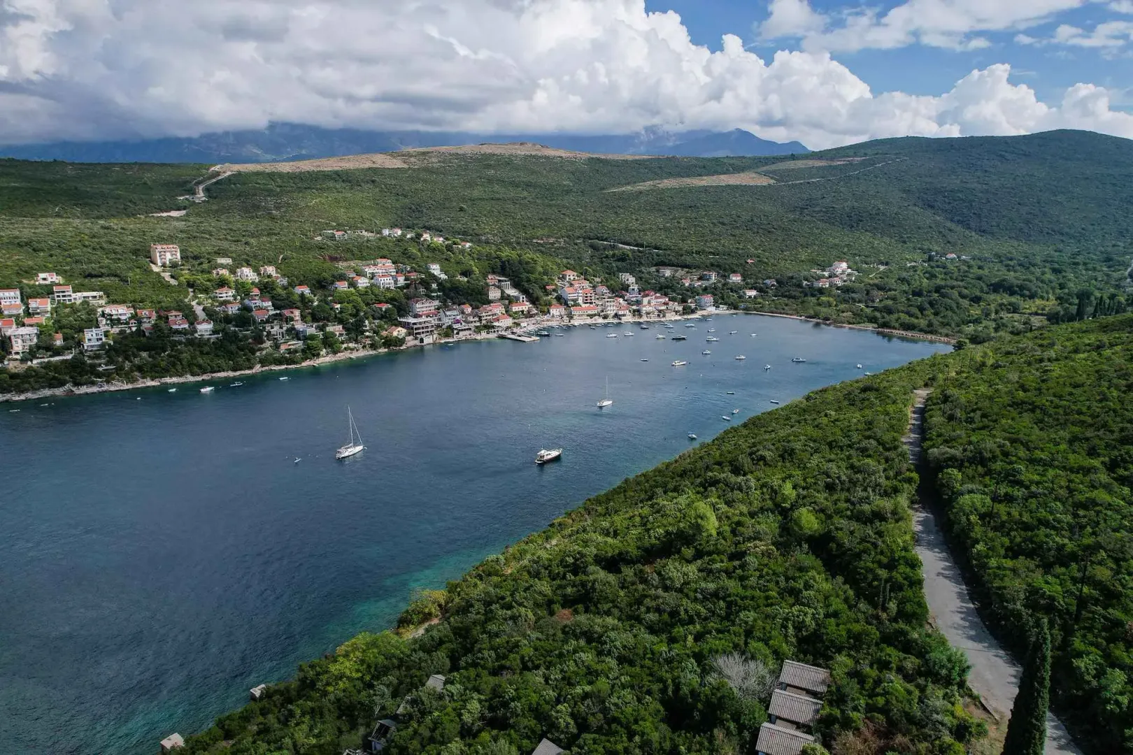 Pogled iz vazduha na zaliv, naselje i okolna brda.