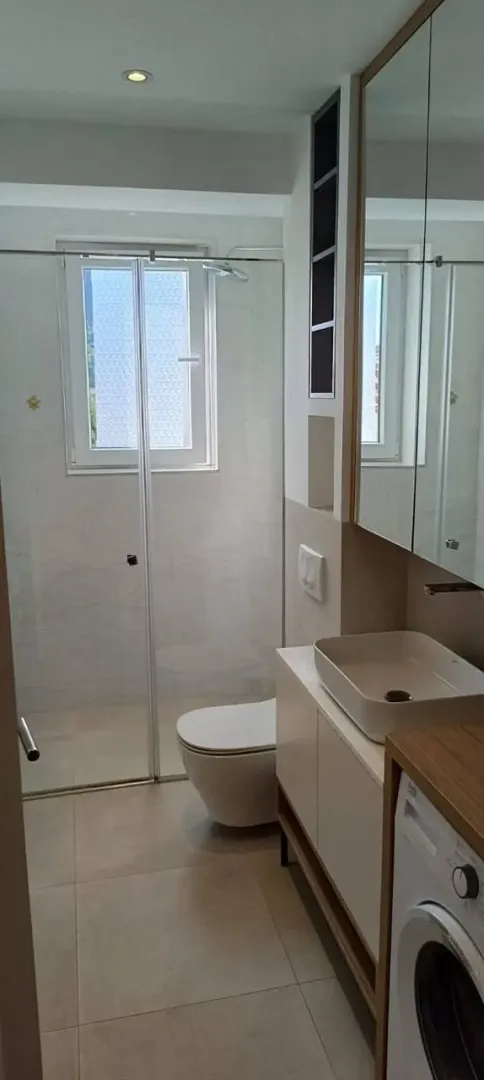 Moderne kupatilo sa tuš kabinom, umivaonikom i wc šoljom.