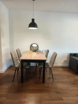 Dining area with a wooden table and upholstered chairs in a bright interior. - image 11