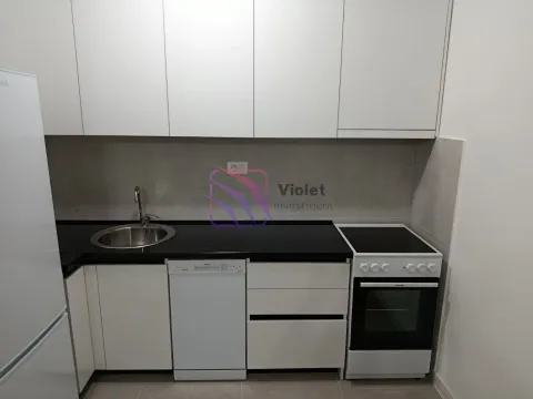 Small white kitchen with a black countertop and built-in appliances. - image 3