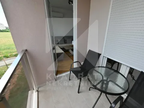 Small furnished balcony with a table, chairs, and a view of nature. - image 5