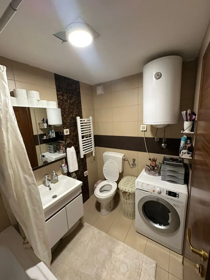 Manje kupatilo sa sanitarijama, umivaonikom i veš mašinom.