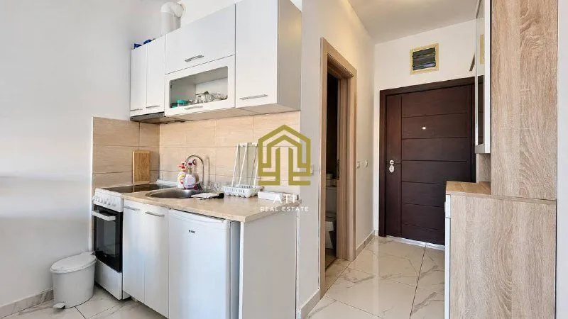 Smaller kitchen with white cabinets and sink.