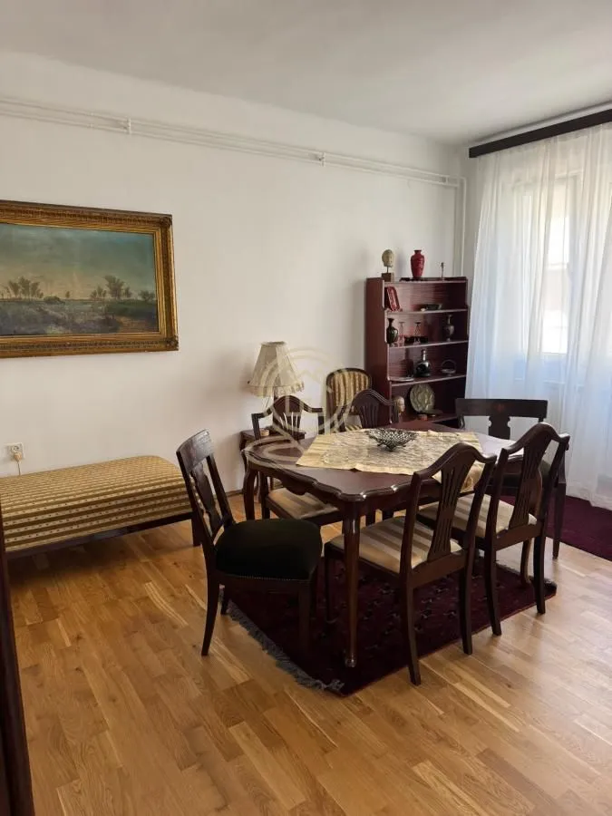 Living room with a dining table, chairs, and a bookshelf.