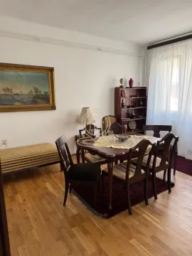Living room with a dining table, chairs, and a bookshelf. - image 5