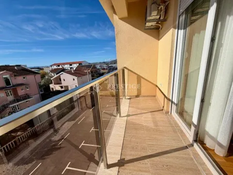 Spacious balcony with a glass railing and a view of the surrounding buildings and neighborhood. - image 13