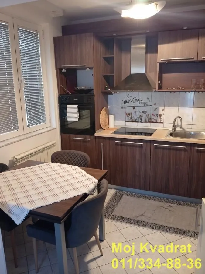 Kitchen with dark wooden units and a dining table.
