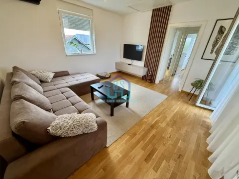 Dnevni boravak sa garniturom za sedenje, stočićem i televizorom. - image 3