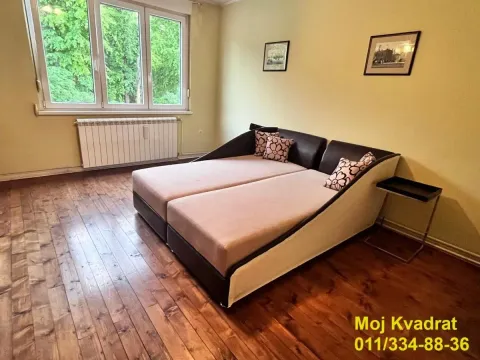 Spavaća soba sa bračnim krevetom, drvenim podom i prozorom sa pogledom na zelenilo. - image 12
