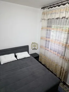 Spavaća soba sa bračnim krevetom i prozorom sa zavesama. - image 4
