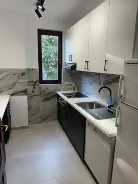 Modern kitchen with white and dark cabinets and a window. - image 16