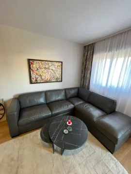 Living room with a sectional sofa, a round coffee table, and an artwork on the wall. - image 14