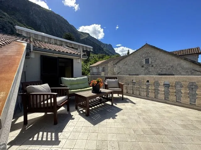 Spacious terrace with outdoor seating and a view of the surrounding mountains.