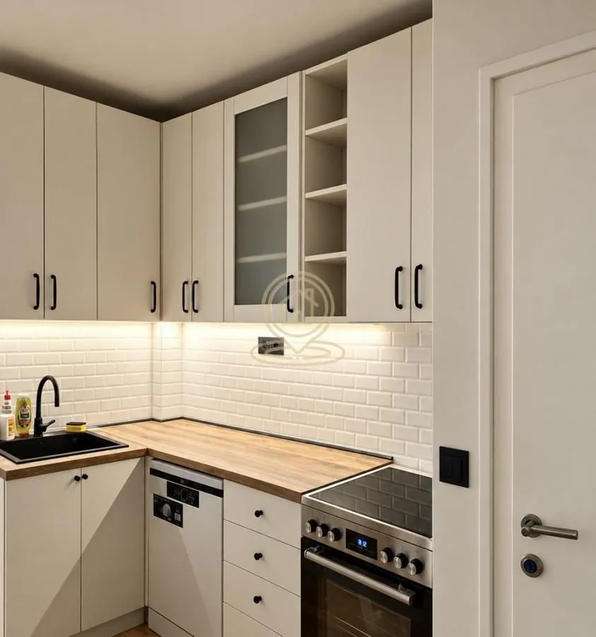 Small kitchen with white cabinets and a wooden countertop.