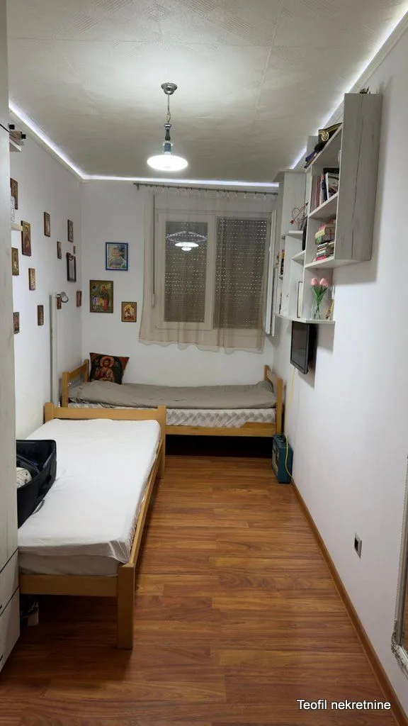 Dva drvena kreveta u spavaćoj sobi sa laminatom.