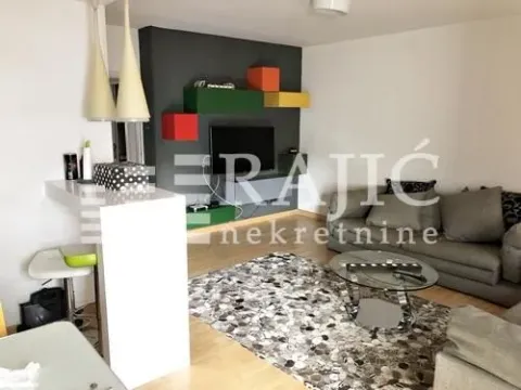 Living room with a sofa, coffee table, and bar counter in an open-plan space. - image 3