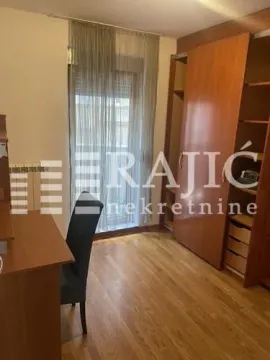 Furnished bedroom with a desk and a built-in wardrobe. - image 7