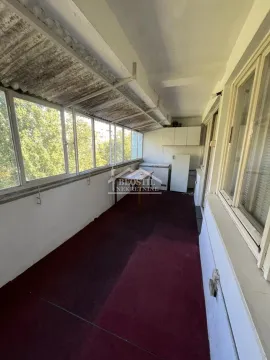 Enclosed balcony with large windows and a view of greenery. - image 7