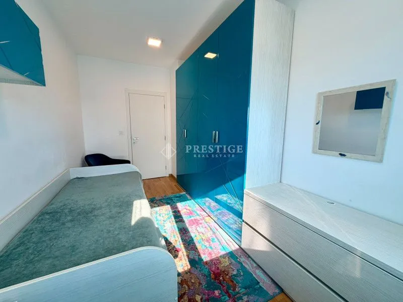 Furnished bedroom with a bed and a large blue wardrobe.