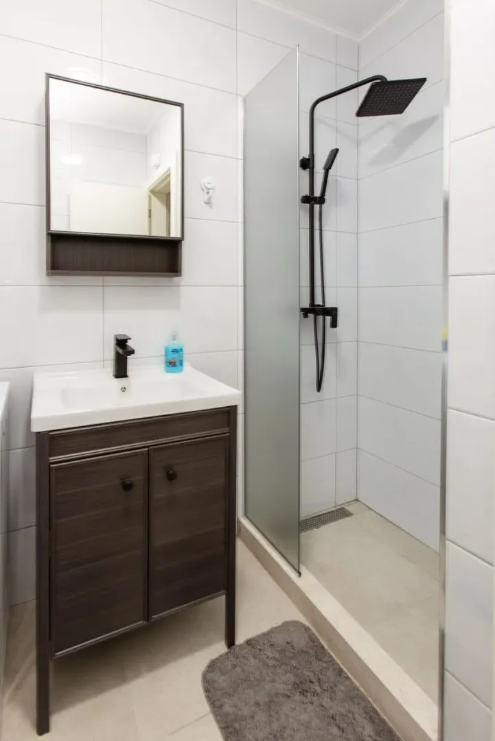 Modern bathroom with a sink, mirror, and walk-in shower.