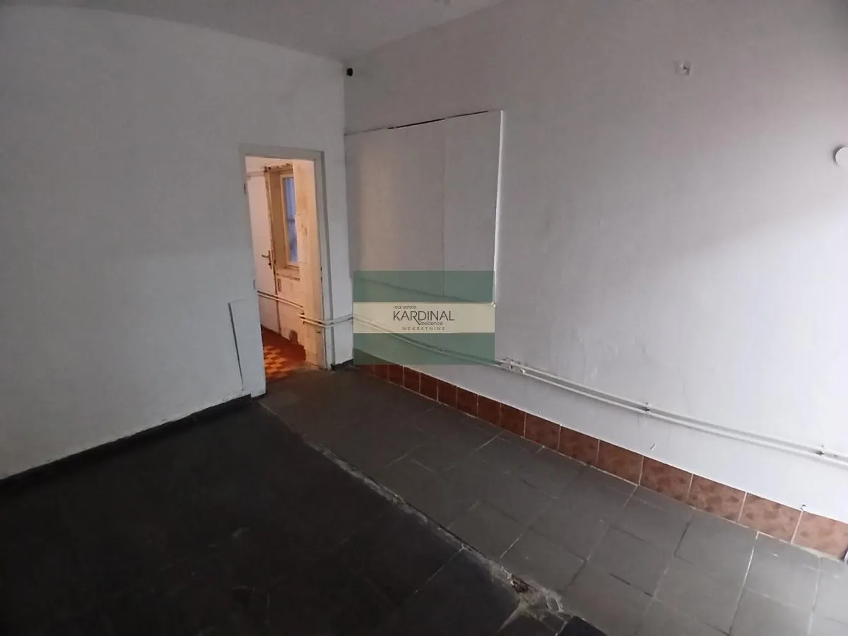 Empty room with tiled floor and a door leading to another room.
