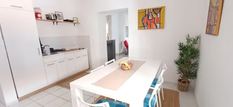 Bijela kuhinja sa trpezarijskim stolom i stolicama. - image 8