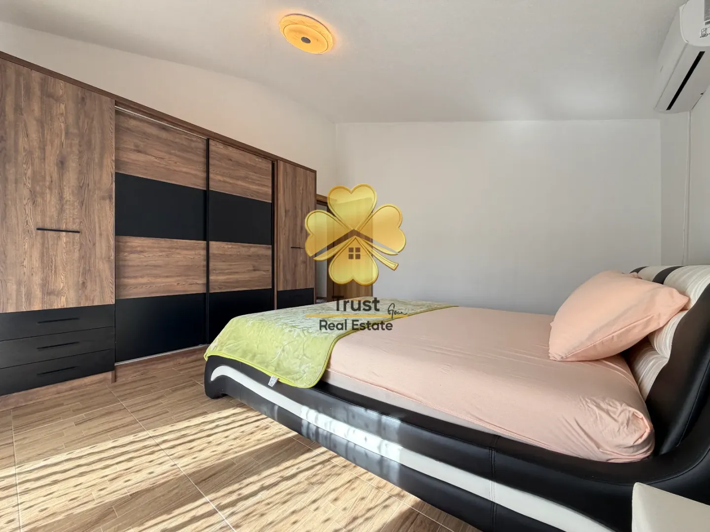 Furnished bedroom with a double bed and a large wooden wardrobe.