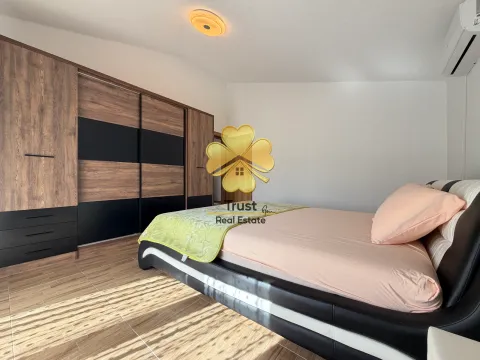 Furnished bedroom with a double bed and a large wooden wardrobe. - image 15