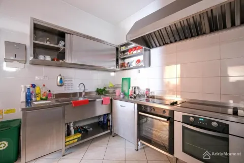 Commercial kitchen with stainless steel elements and built-in appliances. - image 14