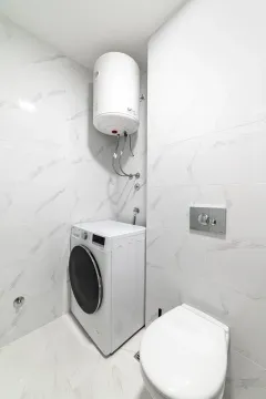 Moderno opremljeno kupatilo sa veš mašinom i bojlerom. - image 4