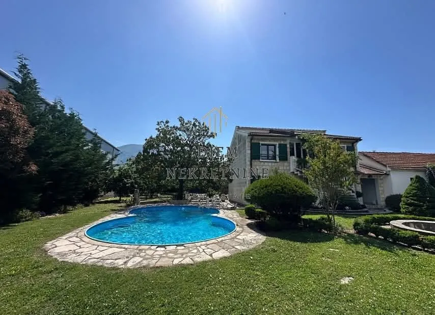 Exterior of the house with a swimming pool and landscaped yard.