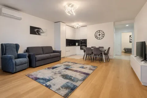 Modern living room with a sofa, dining area, and kitchen in the background. - image 10