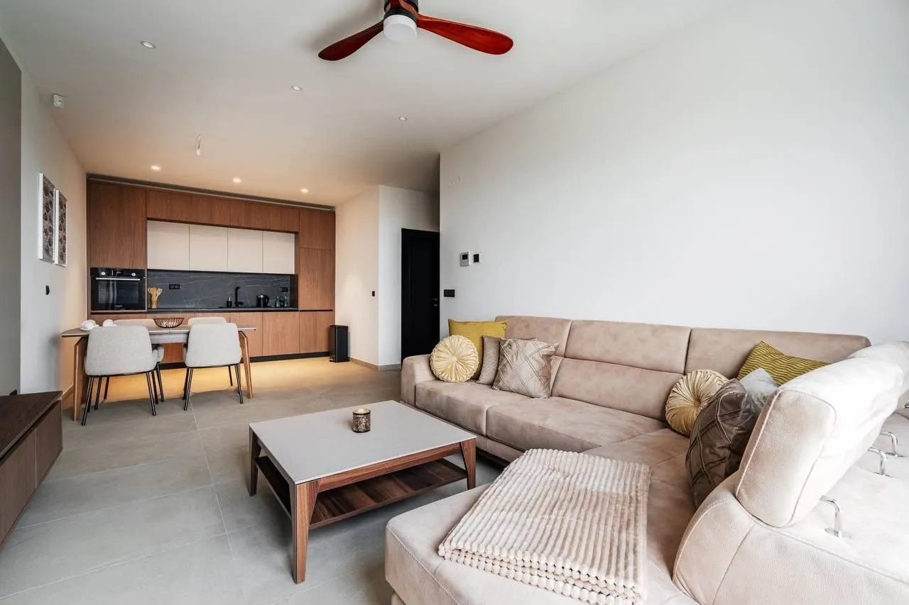 Spacious living room with a sectional sofa and dining area in the background.