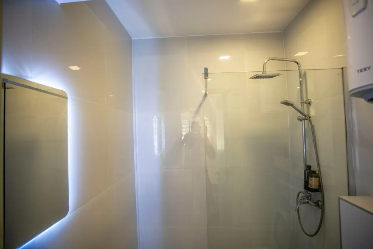 A modern bathroom equipped with a walk-in shower and a mirror.