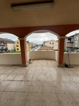 Prostrana popločana terasa sa lukovima i pogledom na naselje. - image 4