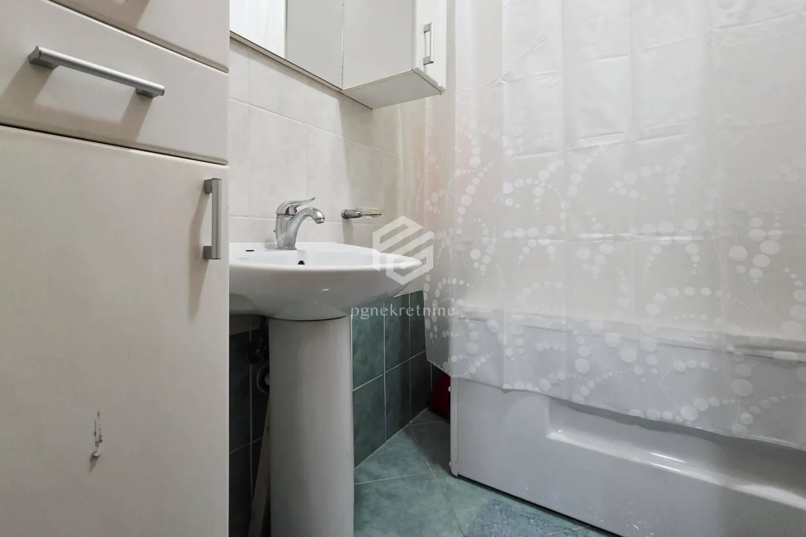View of the bathroom with a sink and a bathtub.