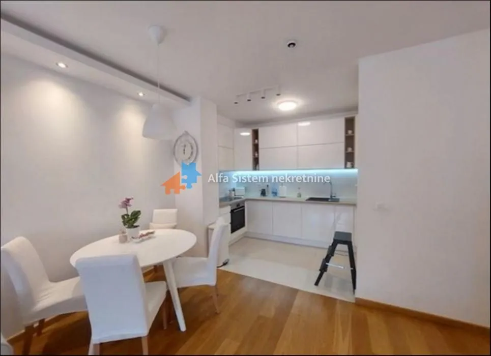 Kitchen with dining area and white units.