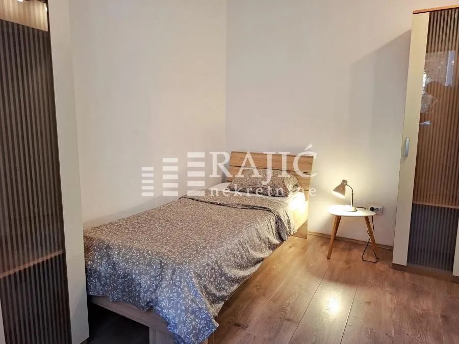 Furnished bedroom with a bed and wardrobe.